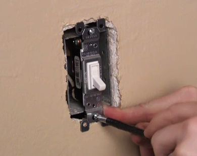 Mount the light switch back onto the wallbox